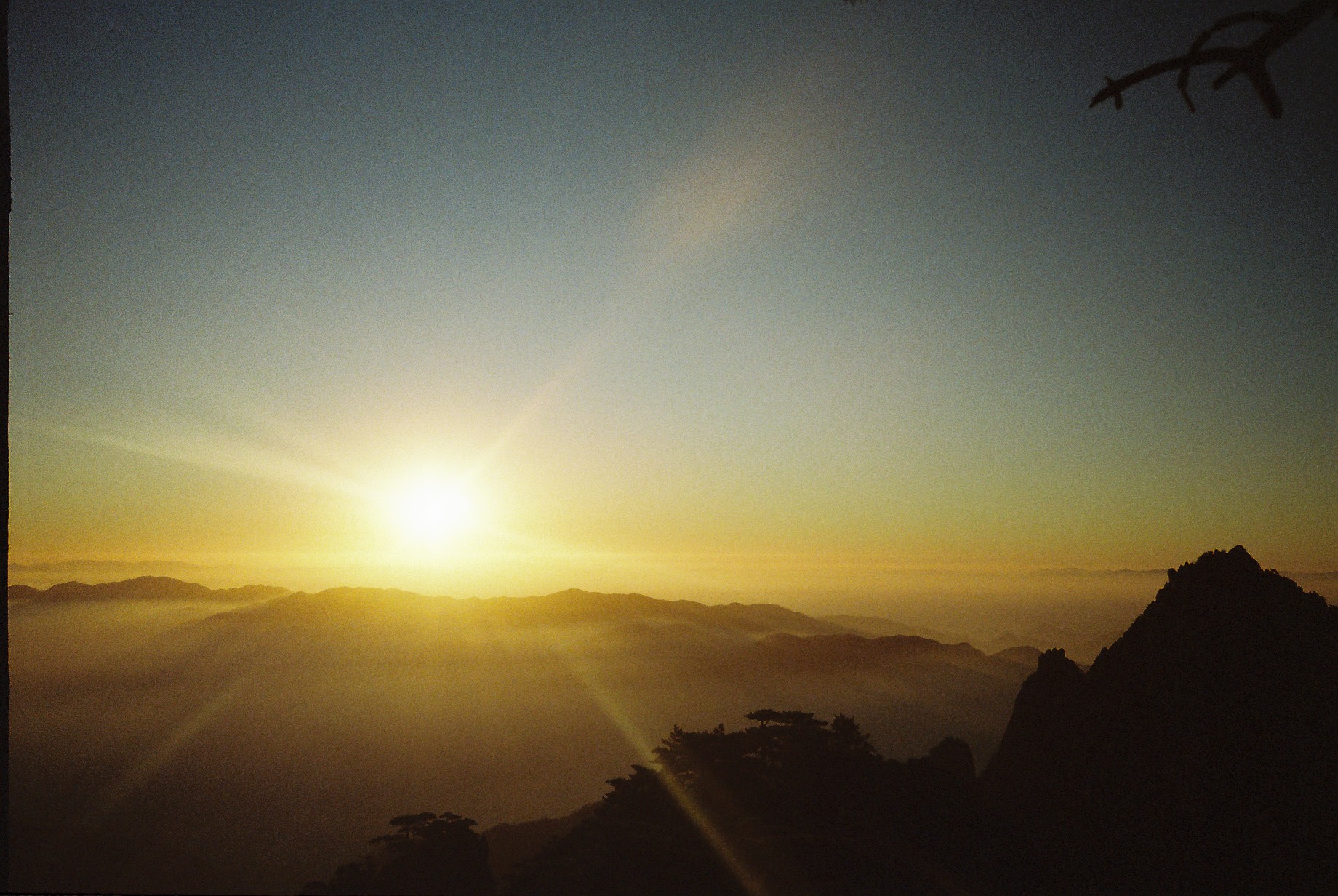 Golden sunlight above overlapping mountain silhouettes